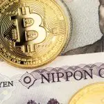 Een afbeelding van bitcoin (BTC) munten op japanse yen briefgeld
