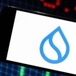 Een afbeelding van cryptomunt Sui (SUI) op een mobiele telefoon met marktdata op de achtergrond