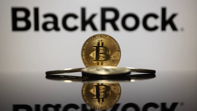 Een afbeelding van een bitcoin (BTC) munt met op de achtergrond het logo van BlackRock, een grote vermogensbeheerder