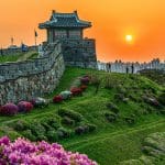 Een afbeelding van een fort in zuid korea met een skyline op de achtergrond