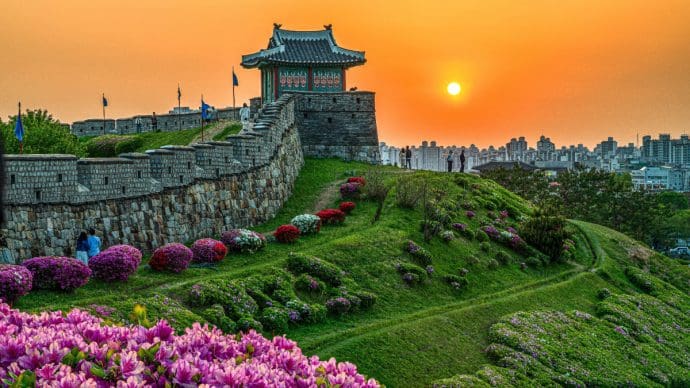 Een afbeelding van een fort in zuid korea met een skyline op de achtergrond