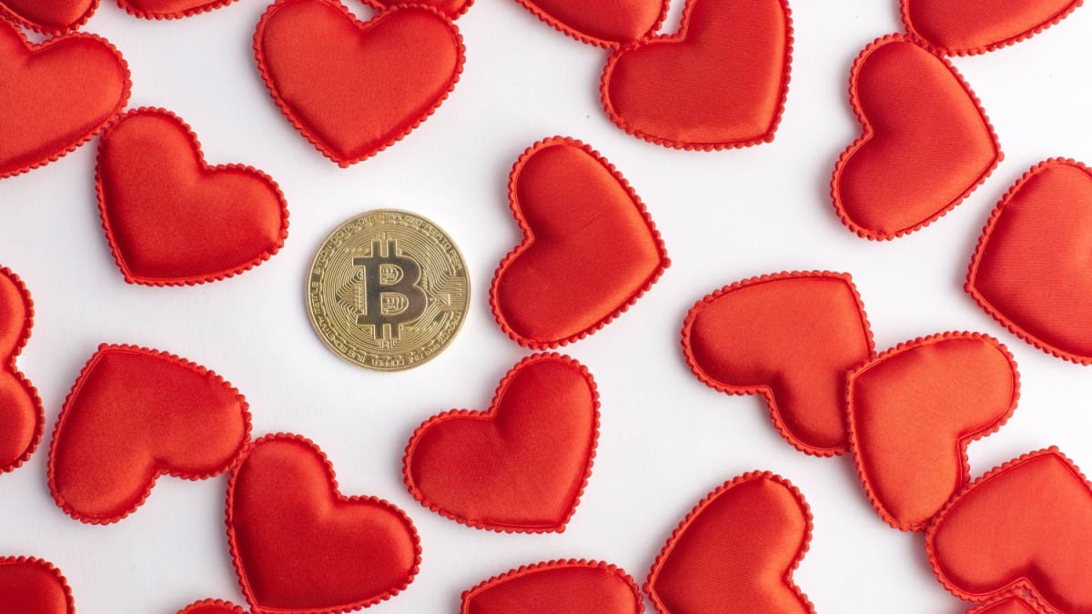 Een afbeelding van een bitcoin (BTC) munt tussen allemaal valentijn hartjes