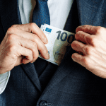 Man stopt eurobiljet in jas