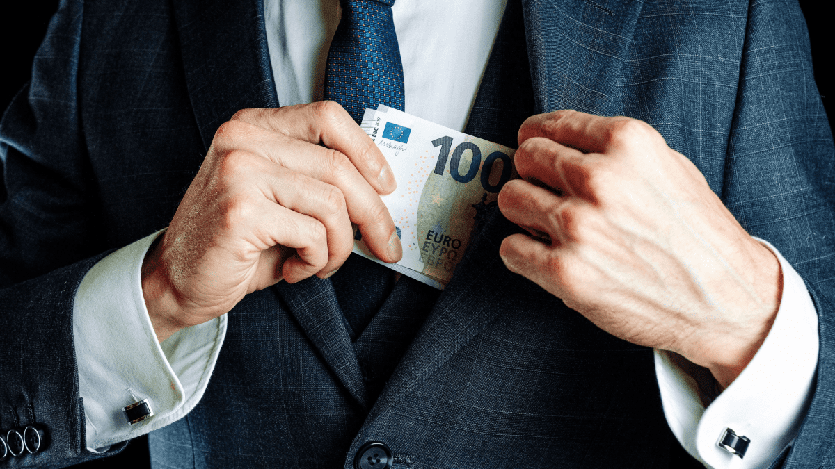 Man stopt eurobiljet in jas