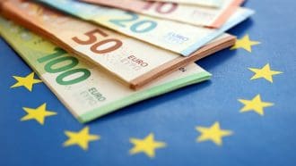 Stapel euro biljetten en EU vlag