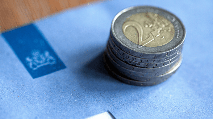 blauwe belastingbrief en euromunten