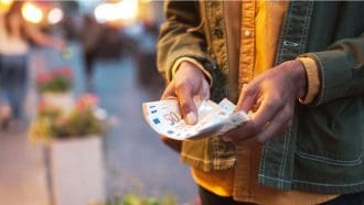 Een afbeelding van een man die euro bankbiljetten van 50 euro vasthoudt in zijn handen