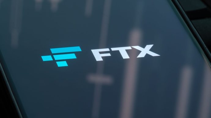 FTX logo op telefoon rooie grafiek