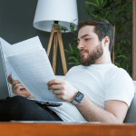 Man zit achterover met papieren en laptop