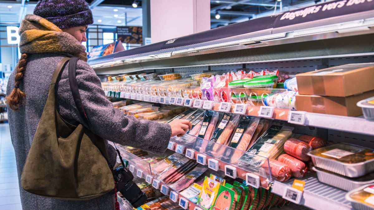 Nederlander pakt plakjes worst in de Albert Heijn