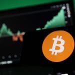 Een afbeelding van een bitcoin (BTC) logo met een grafiek van de koers op de achtergrond