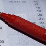 Een afbeelding van financiele cijfers met een rode pen