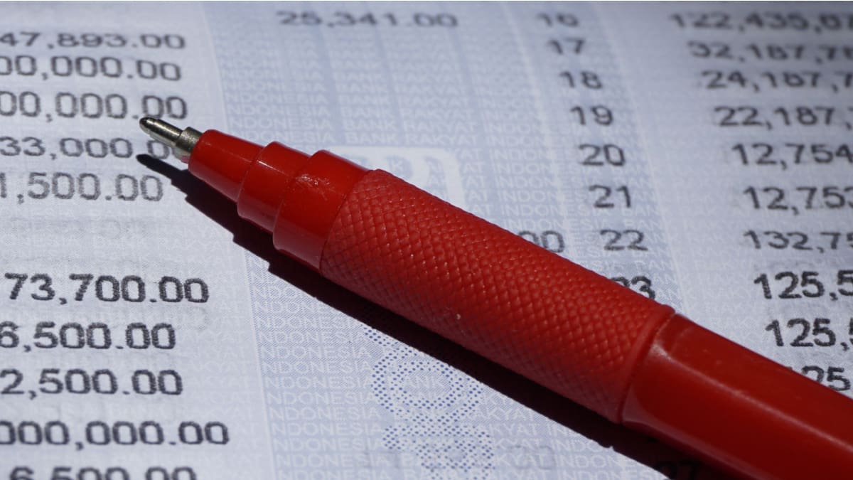 Een afbeelding van financiele cijfers met een rode pen