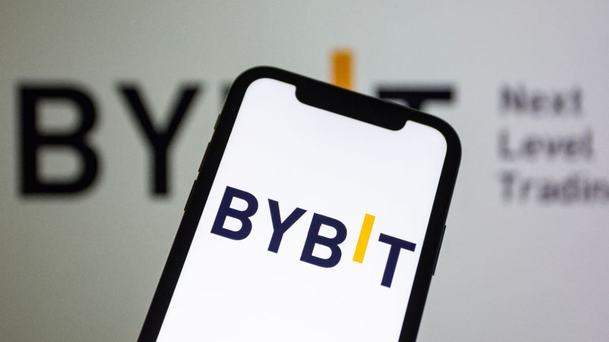 Een afbeelding van het Bybit logo op een mobiele telefoon en op de achtergrond
