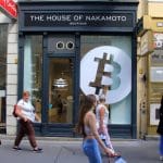 Een afbeelding van 'the house of nakamoto' met een bitcoin logo op de gevel van een winkel _ huis