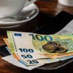 Een fooibakje met contant geld, waaronder 100, 50 en 20 euro biljetten