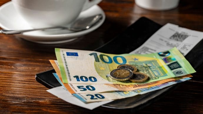 Een fooibakje met contant geld, waaronder 100, 50 en 20 euro biljetten