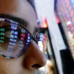 Een afbeelding van een crypto trader die naar koersen en marktdata kijkt
