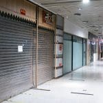 Een afbeelding van gesloten deuren van failliete bedrijven in een winkelcentrum