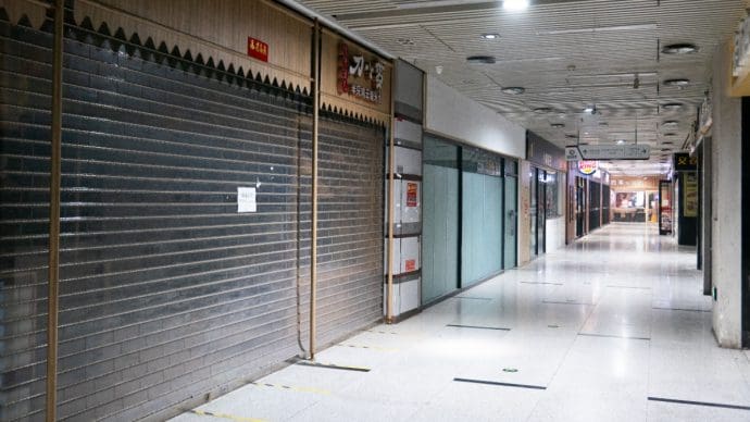 Een afbeelding van gesloten deuren van failliete bedrijven in een winkelcentrum