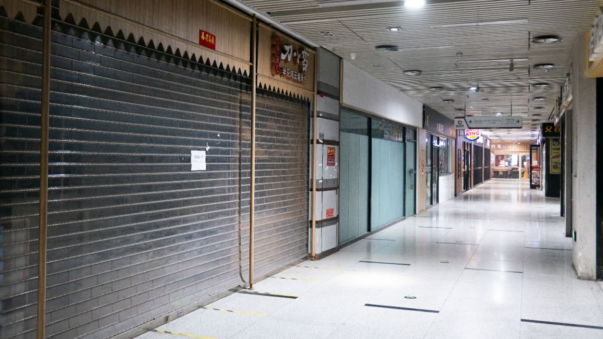Een afbeelding van gesloten deuren van failliete bedrijven in een winkelcentrum