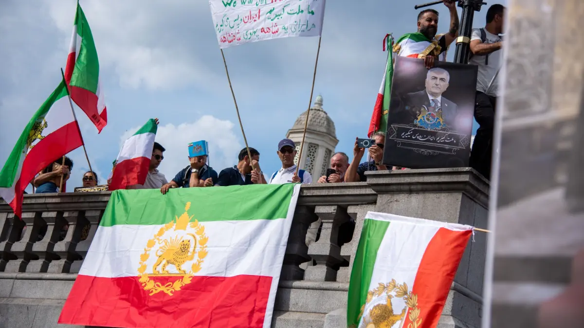 Een afbeelding van mensen met Iraanse vlaggen en spandoeken