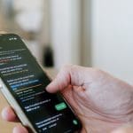 Man bekijkt sms op mobiele telefoon