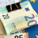 Een afbeelding met euro bankbiljetten op een Europese vlag