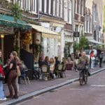 Een afbeelding van fietsende en lopende Nederlanders en toeristen in Amsterdam