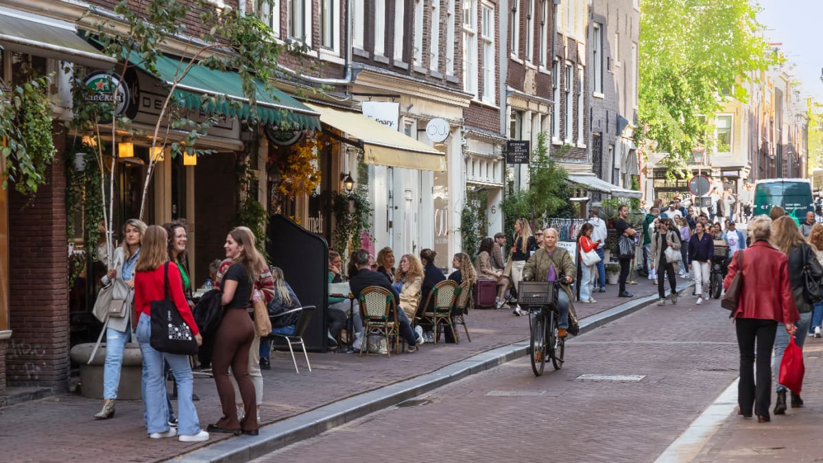 Een afbeelding van fietsende en lopende Nederlanders en toeristen in Amsterdam