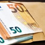 Een afbeelding van vijftig en twintig euro biljetten in een envelop
